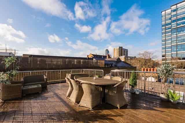 Spacious rooftop terrace in Shoreditch for events with stylish wicker furniture and city views.