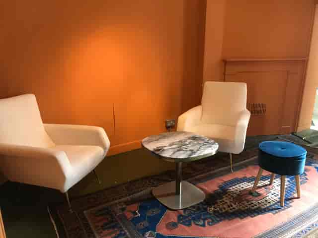 Cozy meeting space in Café Babka with modern armchairs and marble table for brainstorming.