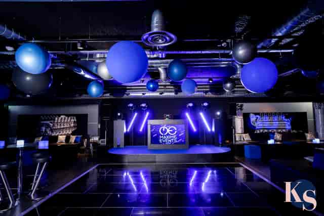 Modern event space with blue and black decor, ideal for presentations and celebrations.