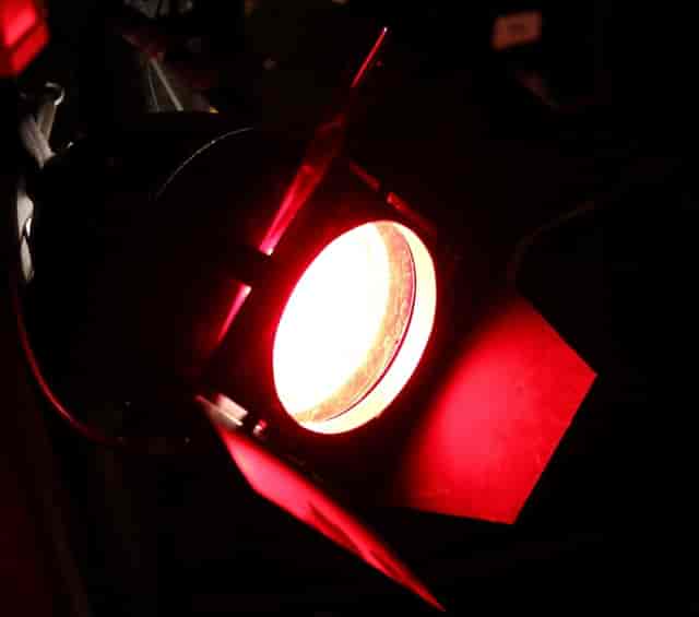 Black Box Theatre stage light casting vibrant red hue for events and performances.