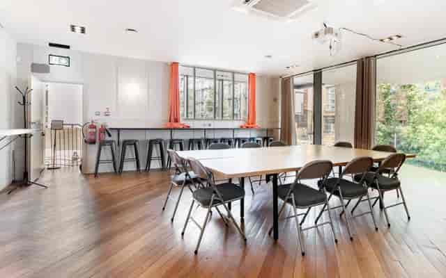 Versatile conference space with large table, ideal for workshops and meetings.