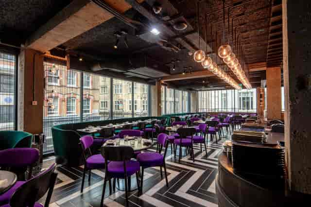 Modern dining room at Chotto Matte with purple chairs, ideal for upscale events.