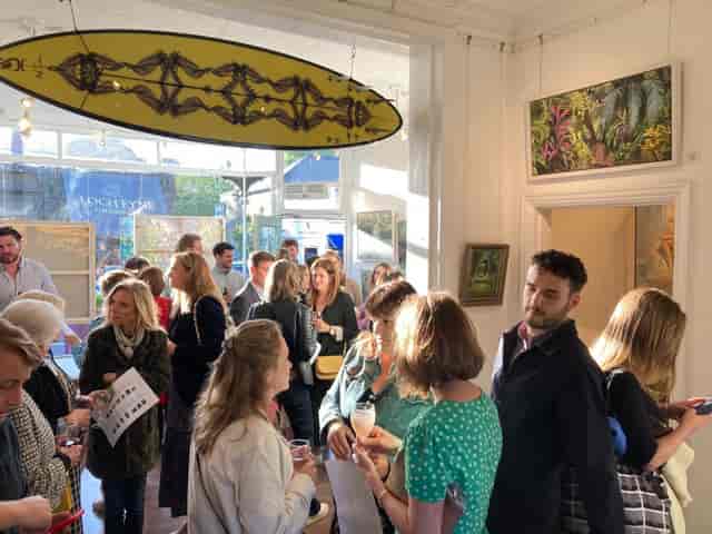 Vibrant networking event in Ad Lib Gallery with art and engaged attendees.