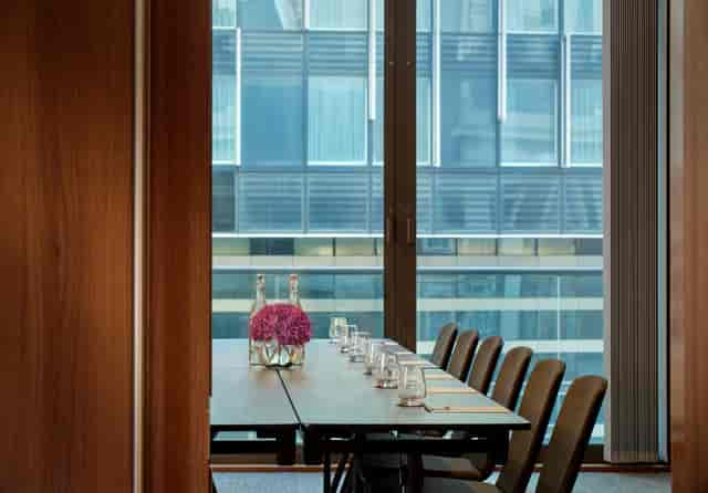 Modern Putney Suite meeting room with wooden table, ideal for intimate business events.
