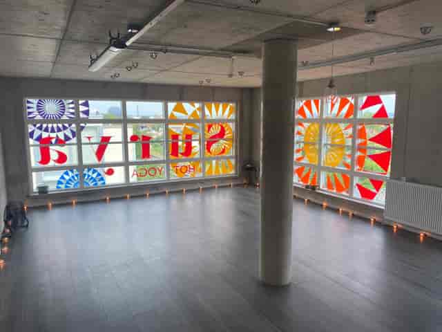 Spacious Surya Studio 2 with stained glass, perfect for yoga workshops and retreats.