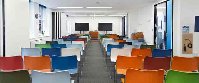 Flexible meeting space with colorful chairs, ideal for workshops and seminars.