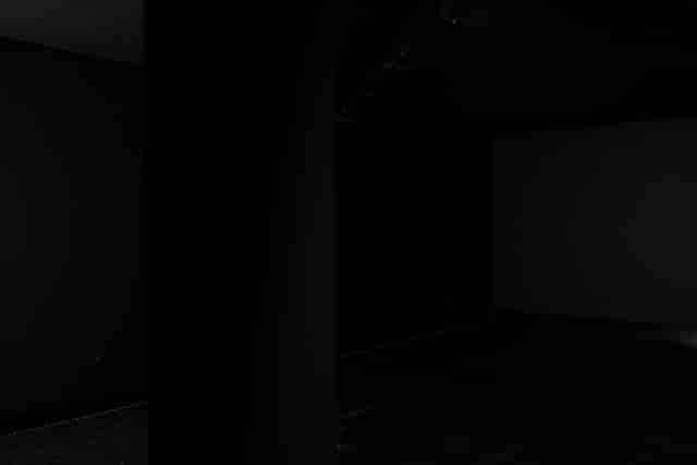 Minimalist dimly lit venue in Blackout studio for versatile events and gatherings.