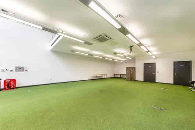Versatile event space with artificial grass flooring for team-building and workshops.