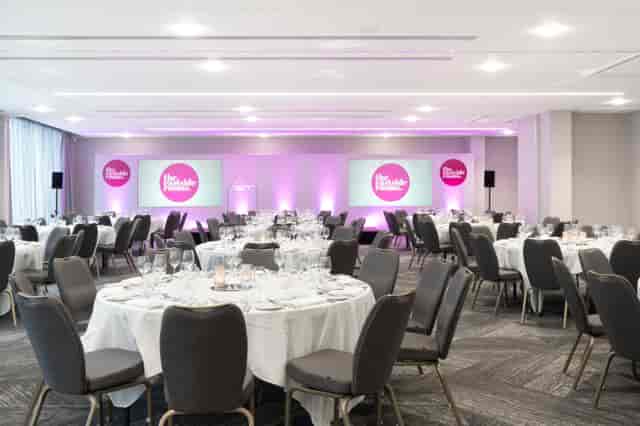 Elegant event space with round tables, ideal for corporate gatherings and conferences.