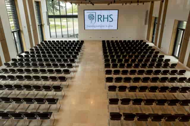Hilltop Garden Room at RHS Wisley, spacious venue for conferences with black chairs.