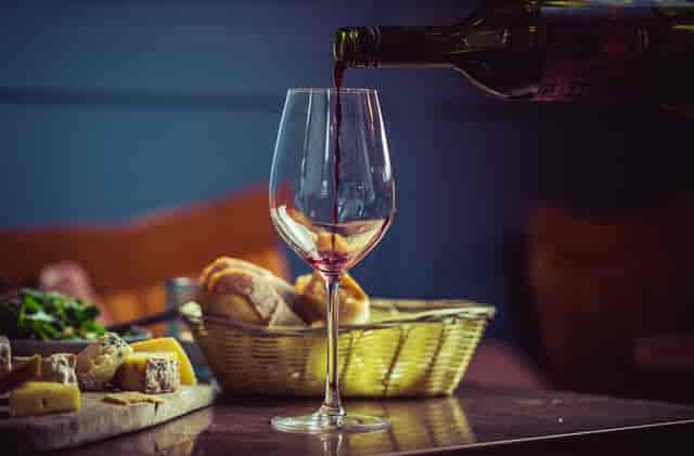 Elegant table setting with red wine, cheese, and bread for networking events.