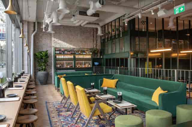 Modern lounge with green seating, ideal for casual meetings and networking events.