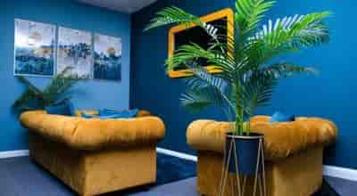 Stylish Lounge Studio with blue walls and yellow sofas for creative meetings.