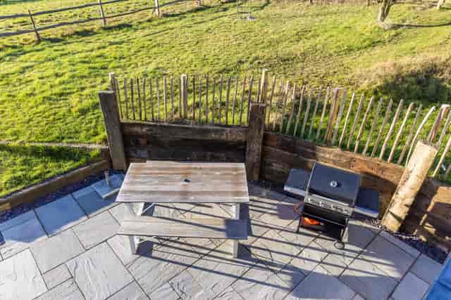 Outdoor event space at The Grain Store Lewes with rustic picnic table and grill.