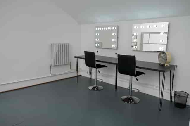 Minimalist makeup stations with illuminated mirrors at Mello Studios Hackney for event grooming.