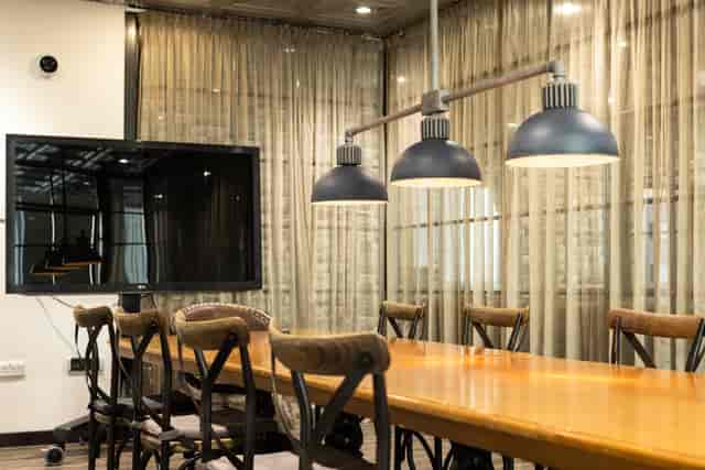 Modern meeting room with wooden table, ideal for presentations and collaboration events.