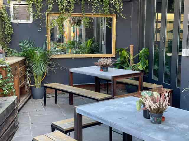 Stylish outdoor meeting space with concrete tables in The Enchanted Garden, ideal for gatherings.