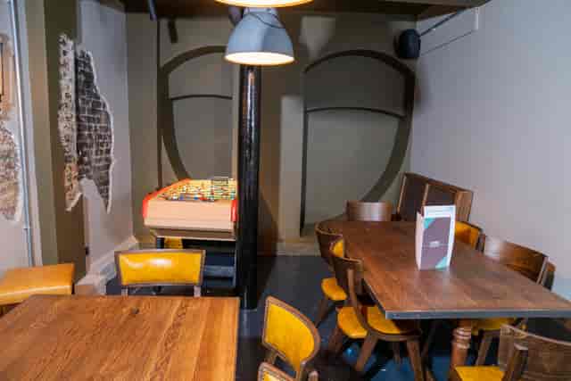 Cozy meeting space with wooden tables and pool table at Bar Kick for brainstorming sessions.