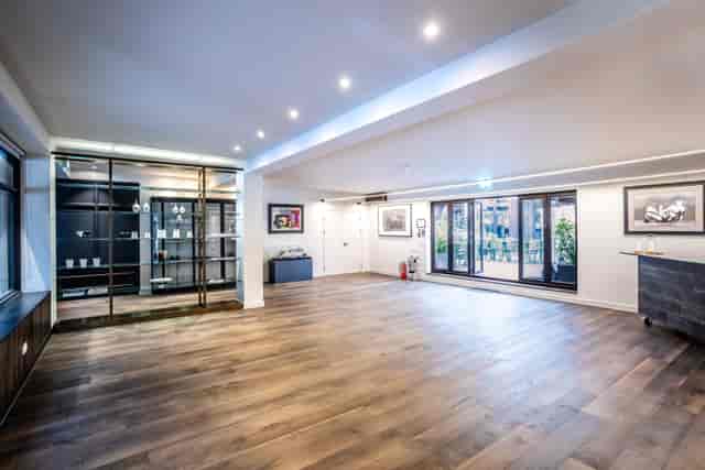 Modern event space with polished wooden floor, ideal for corporate meetings and social gatherings.