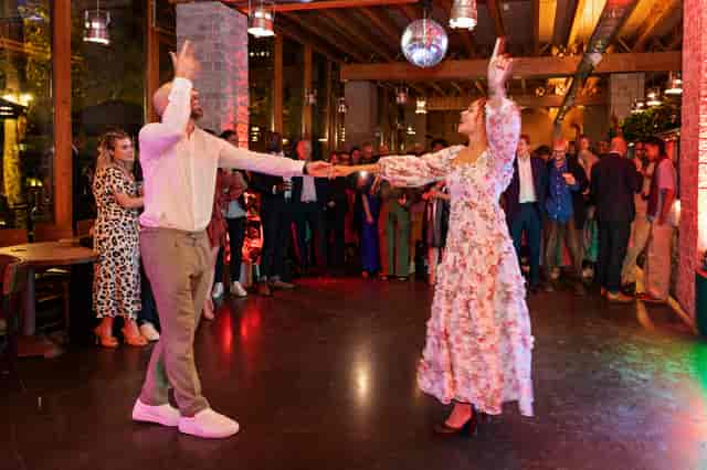 Couple dancing under disco ball at vibrant event in The Greenroom, celebrating connection.
