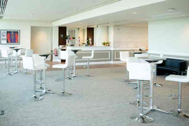 Modern event space at Epsom Downs Racecourse with high-top tables for networking events.