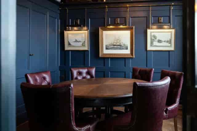Sophisticated meeting space with round table and plush chairs in Enderby House.