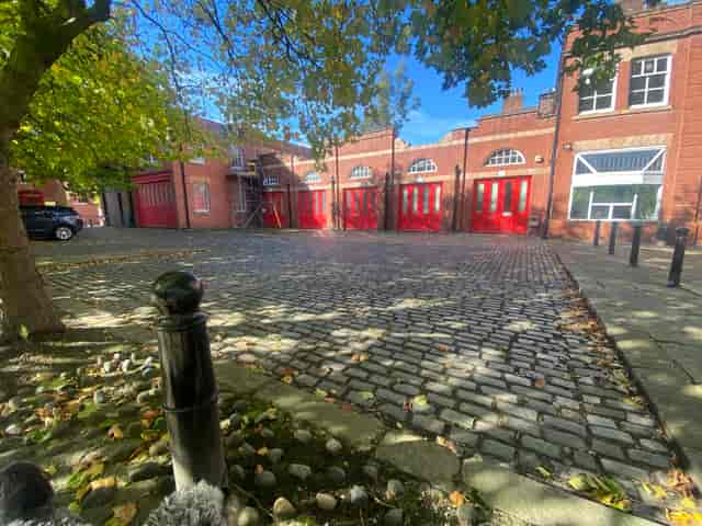 Charming outdoor event space at Albert Bentley Place with cobblestone paving and red doors.
