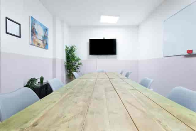 Modern meeting room with large wooden table at Runway East Soho for collaborative events.