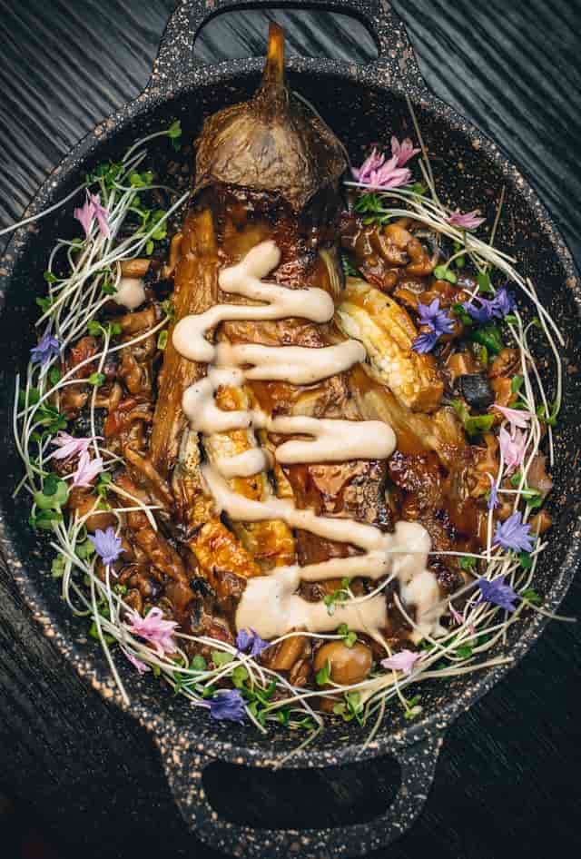 Elegant dish with fresh herbs and flowers for event catering at Arros QD.