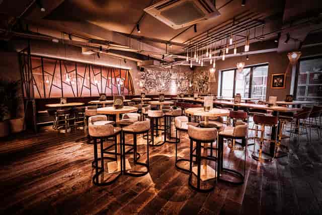 Stylish bar area with high-top tables, perfect for networking events and gatherings.