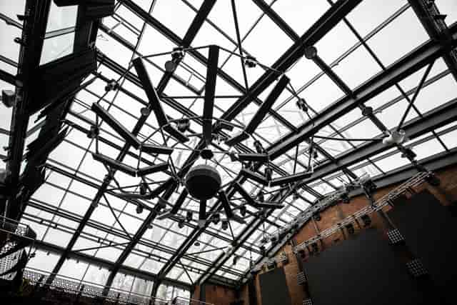 Modern event space with glass ceiling and chandelier at Studio 338, perfect for gatherings.