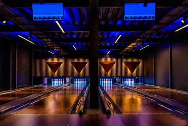 Modern bowling alley with blue lighting at PINS Social Club for corporate events.