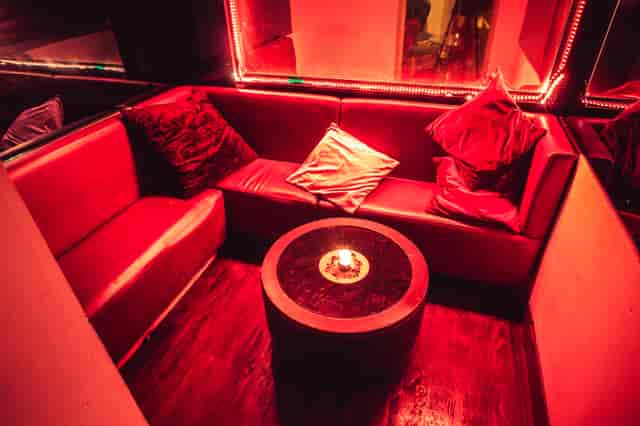 Cozy lounge with plush red seating for VIP receptions and networking events.
