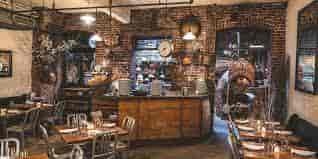 Rustic wine bar with exposed brick, ideal for intimate gatherings and casual meetings.