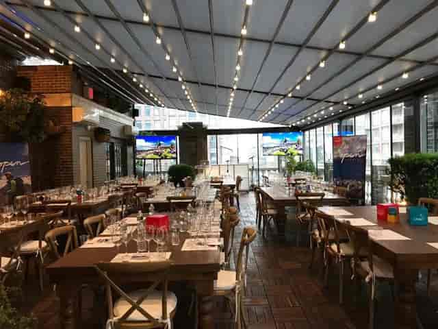 Open-air terrace event space with elegant tables, ideal for corporate gatherings and dinners.