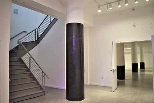 Versatile event space with staircase, ideal for corporate meetings and social gatherings.
