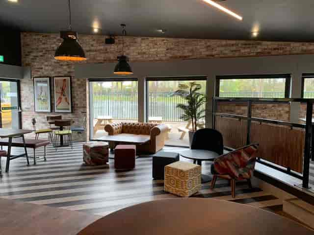 Event Hire in Powerleague Birmingham: modern meeting space with cozy seating for networking.