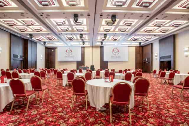 Kingdom Suite at Millennium Gloucester: elegant conference venue with round tables and screens.