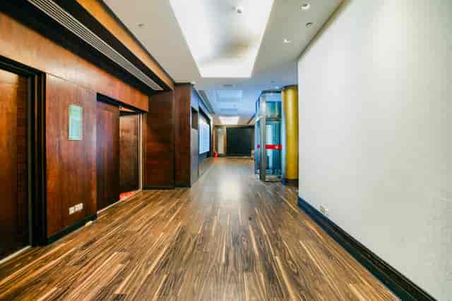 Kingdom Suite corridor at Millennium Gloucester, warm wood finishes for events and networking.