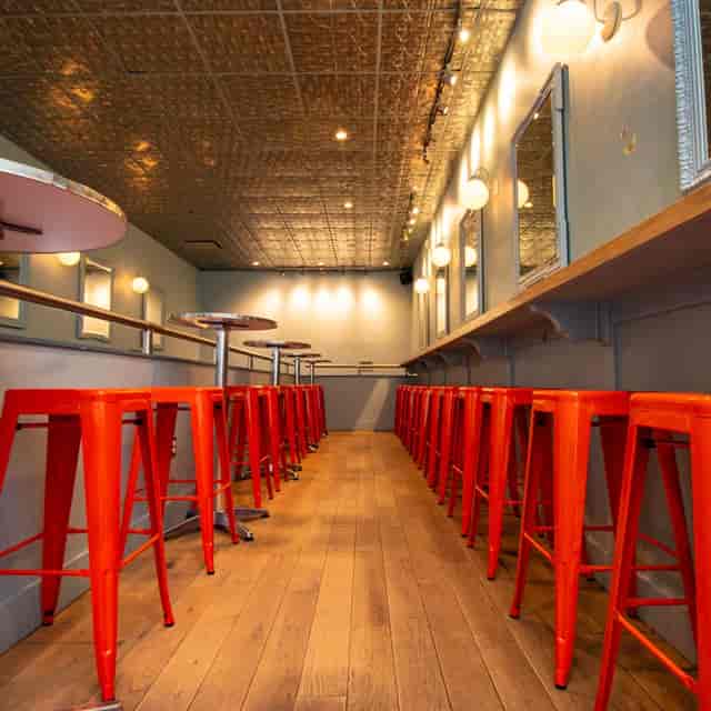 Enhanced cocktail experience at Morris American Bar with vibrant orange stools.