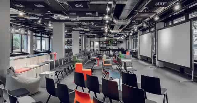 Versatile event space with colorful chairs for dynamic meetings in Frankfurt.
