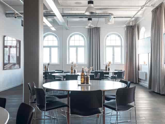 Modern event space in Fotografiska, Stockholm with round tables for workshops and networking.