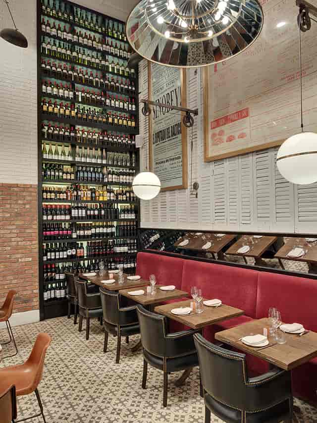 Stylish Vinoteca restaurant interior with vibrant wine wall, ideal for intimate events.