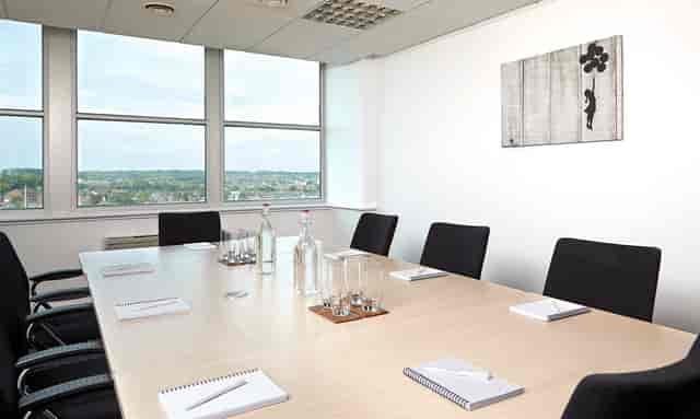 Modern meeting room with wooden table and ergonomic chairs for corporate events.