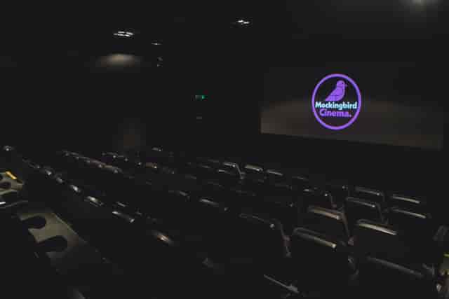 Modern event space with tiered seating and large screen for corporate events and screenings.