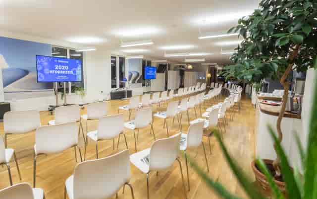 Rooftop Kitchen event space with white chairs, ideal for presentations and networking.