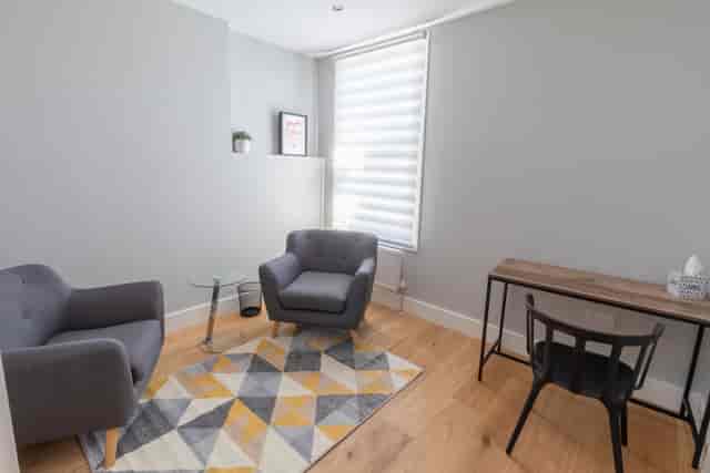 Cozy therapy room with glass table for intimate discussions and brainstorming sessions.