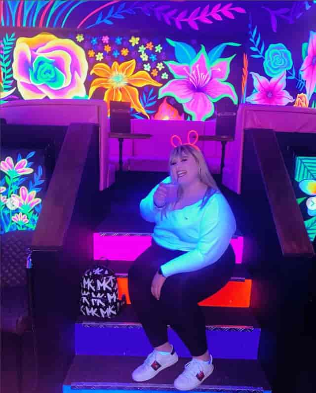 Vibrant neon-lit event space with floral backdrops for lively parties and gatherings.