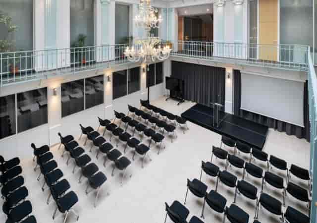 La Verriere Clery event space with sleek chairs and elegant chandelier for corporate gatherings.