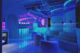 Modern event space in Otherworld VR, London with vibrant blue and purple lighting.